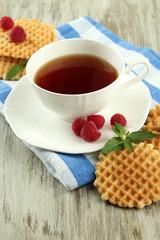 Cup of tea with cookies and raspberries on table close-up