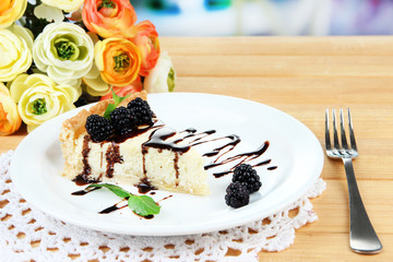 Slice of cheesecake with chocolate sauce and blackberry