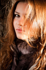 Closeup portrait of cute redhead girl posing in sun light