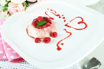 Panna Cotta with raspberry sauce, on wooden background