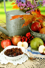 Juicy apples in basket on table on natural background