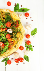 Tasty vegetarian pizza and vegetables on wooden table