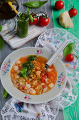 Traditional italian soup minestrone with pesto sauce