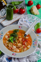 Traditional italian soup minestrone with pesto sauce