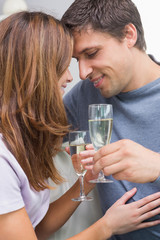 Close-up of a romantic couple with flutes at home