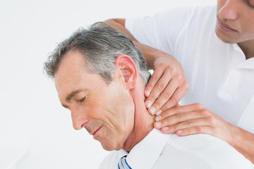Obraz na płótnie Canvas Male chiropractor massaging patients neck