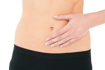 Close-up mid section of a fit woman with stomach pain