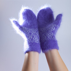 Hands in fluffy lilac mittens