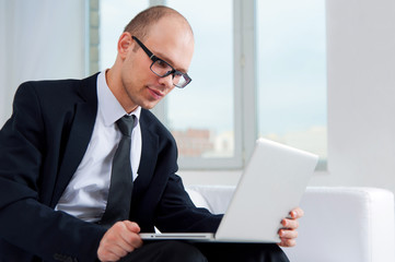 Businessman using laptop on couch