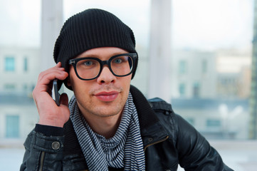 Young smiling man talking on the phone