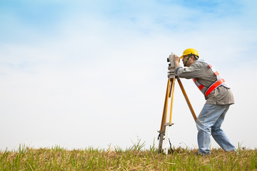Surveyor engineer making measure on the field - obrazy, fototapety, plakaty