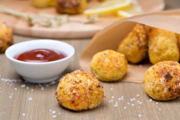 chicken meatballs with tomato sauce on a wooden table, close-up