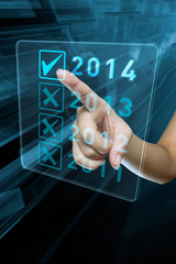 A woman hand selects 2014 on a digital screen