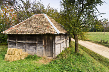 Obraz premium Old wooden barn by a gravel mountain road, Bobija mountain