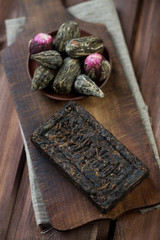 Various compressed tea on a vintage cutting board, above view