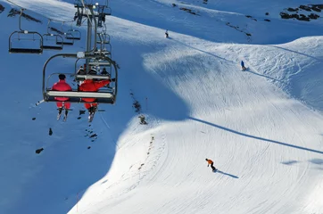 Fototapeten Skiers in a chair lift above the downhills © oksmit