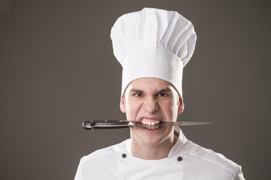 chef with knife in mouth