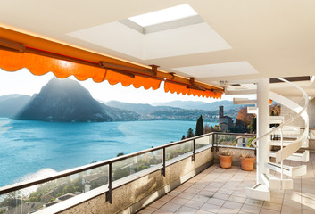 large balcony of a penthouse apartment overlooking the lake