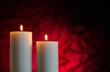 two candles with red background
