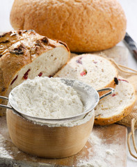 Bread and flour on wooden table.
