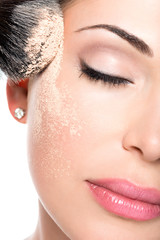 woman  applying dry cosmetic tonal foundation  on the face