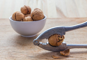 walnuts in a bowl and nutcracker