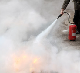 Obraz premium Fire fighting woman demonstrating how to use a fire extinguisher
