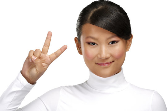 Beautiful happy asian girl showing victory positive sign