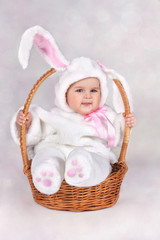 child dressed as a bunny in a basket