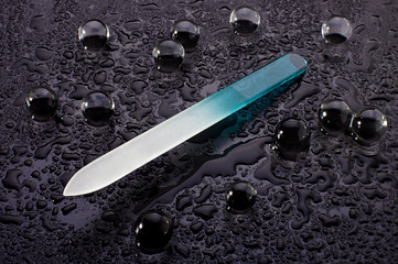 Nail file on the black wet surface