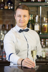 young man working as a bartender in a nightclub bar