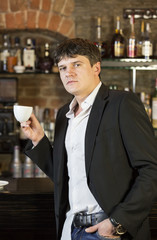Young man drinking coffee in a bar