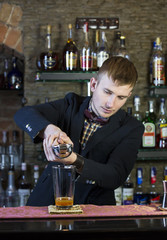 young man working as a bartender in a nightclub bar