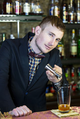 young man working as a bartender in a nightclub bar