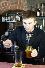 young man working as a bartender in a nightclub bar