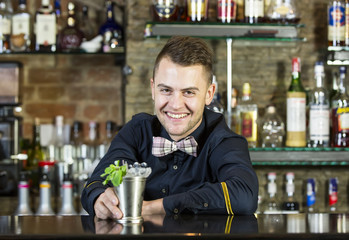 young man working as a bartender in a nightclub bar