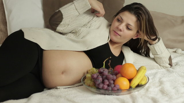 Beautiful pregnant woman with fresh fruits