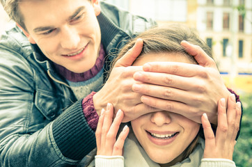 Young man covering the eyes of an happy surprised girlfriend