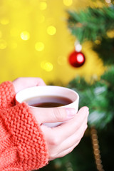 Hands holding mug of hot drink, close-up,