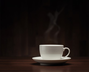 Close up of coffee cup on the table over dark background
