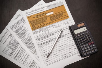 Polish tax form with pen and calculator on desk