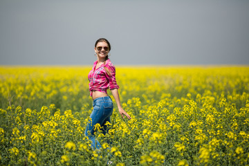 Young beautiful woman in flowering field in summer. Outdoors