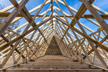 Wood house truss against blue sky 