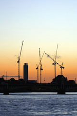Fototapeta na wymiar cranes working over sunset