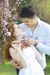 Obraz premium beautiful young couple in love among the flowering trees