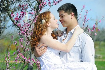 beautiful young couple in love among the flowering trees