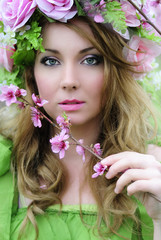 Fototapeta premium Beautiful girl in a flowered garden peach