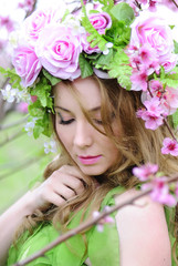 Fototapeta premium Beautiful girl in a flowered garden peach