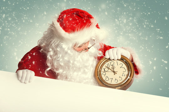 Santa Claus  with white blank banner holding a clock showing sev