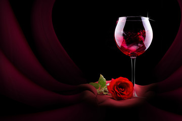 glass of wine with red silk and flower